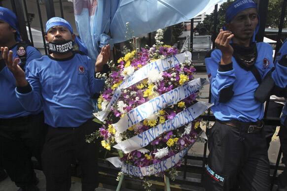 Members of Indonesian Workers Union (SPSI) pray during a solidarity rally for the victims of the collapsed mine at a Freeport Indonesia`s mining area in Papua province, outside the Ministry of Energy And Natural Resources in Jakarta, Indonesia.
