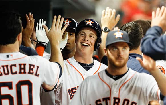 Houston Astros third baseman Matt Dominguez (30) receives high fives in the dugout after hitting a three-run home run against the Kansas City Royals in the fourth inning during a baseball game, in Houston.
