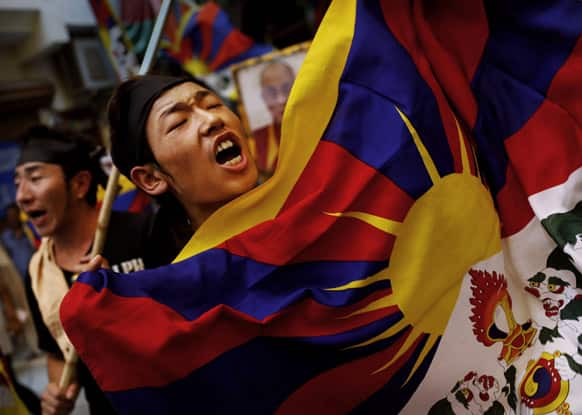 An exiled Tibetan holds a Tibetan flag as he shouts slogans during a protest at a local neighborhood after they were stopped from protesting near the venue where Chinese Premier Li Keqiang was attending a meeting, in New Delhi.