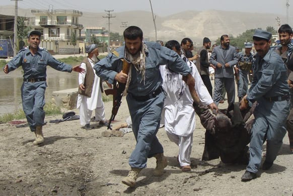 Afghan policemen evacuate a wounded person after a suicide bomber struck outside a provincial council headquarters in Pul-i-Khumri, Baghlan province, northern Afghanistan.