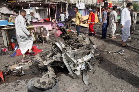 Civilians gather at the site of a car bomb attack in front of a crowded popular restaurant in Basra, 340 miles (550 kilometers) southeast of Baghdad, Iraq.