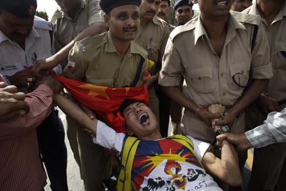 Policemen detain a lone Tibetan protestor who tried to stage a protest against the visit of Chinese Premier Li Keqiang outside the Chinese embassy, in New Delhi.