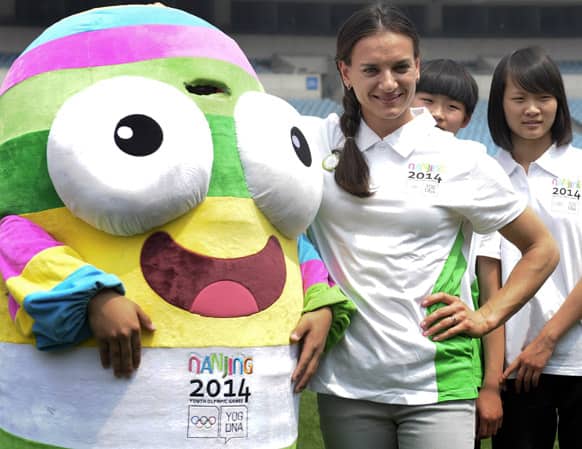 Russian pole vaulter and Olympic gold-medalist Yelena Isinbaeva, right, poses for photos with a mascot of Nanjing 2014 Youth Olympic Games at a stadium in Nanjing, in eastern China`s Jiangsu province.