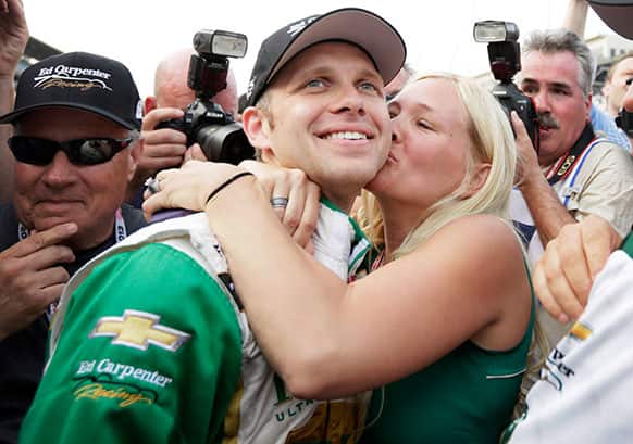 Ed Carpenter gets a kiss from his wife, Heather, after he won the pole for the Indianapolis 500 auto race on the first day of qualifications at Indianapolis Motor Speedway in Indianapolis.