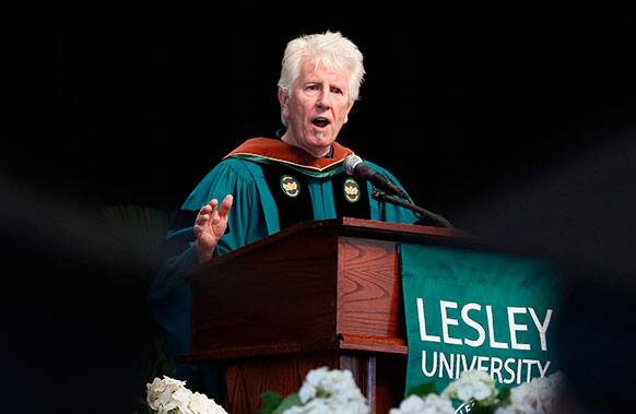 Seen through the mortar boards of graduates, Graham Nash speaks after receiving an honorary degree during the Lesley University commencement in Boston.