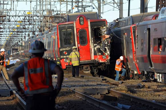 Emergency personnel work at the scene where two Metro North commuter trains collided, near Fairfield, Conn. Bill Kaempffer, a spokesman for Bridgeport public safety, told The Associated Press approximately 49 people were injured, including four with serious injuries.