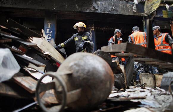 Nepalese firefighters rest after inspecting the scene of a fire at the Pilgrims Book store at Thamel, Nepal.