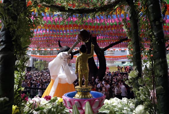 A South Korean believer pours water on a small statue of Buddha to celebrate Buddha`s birthday at Jogye temple in Seoul, South Korea.