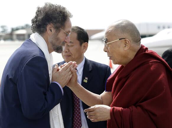 The Dalai Lama greets Ron Marks, dean of the Tulane School of Social Work, as he arrives at Louis Armstrong International Airport in Kenner, La.