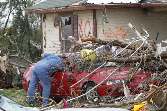 Crushed autos sit amid the rubble as emergency personnel continue search efforts to locate unaccounted for people in the Rancho Brazos neighborhood in Granbury, Texas.