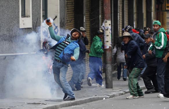 A demonstrator returns a tear gas canister fired by police during a protest by striking miners in La Paz, Bolivia.