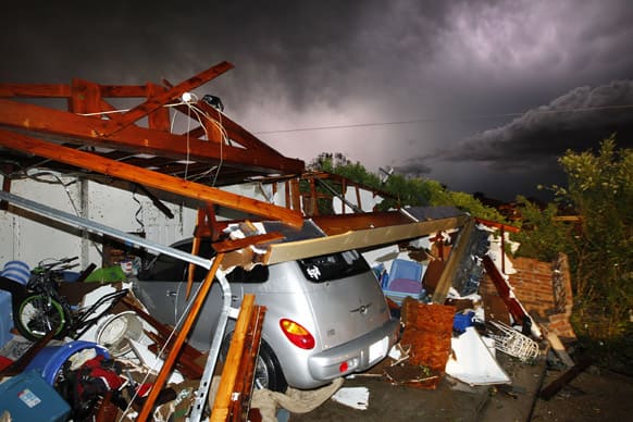 Lightning strikes from a storm illuminate a home damaged by a tornado on Hyde Park Lane at Country Club Rd. in Cleburne.