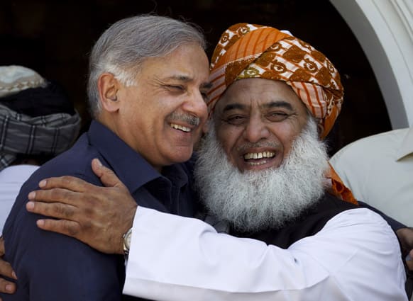 Fazal-ur-Rehman, right, chief of pro-Taliban religious group Jamiat-e-Ulema Islam, JUI-F, embraces Shahbaz Sharif, brother of Pakistan`s former prime minister Nawaz Sharif and leader of Pakistan Muslim League after their negotiation in Islamabad.