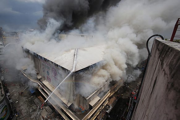 Firemen try to contain the fire at a mall in the shopping district of Divisoria in Manila, Philippines. Authorities are still determining the cause of the fire.