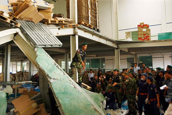 Cambodian rescuers work at the site of a factory collapse in Kai Ruong village, south of Phnom Penh, Cambodia. The ceiling of the factory that makes Asics sneakers collapsed on workers early Thursday, killing two people and injuring seven.