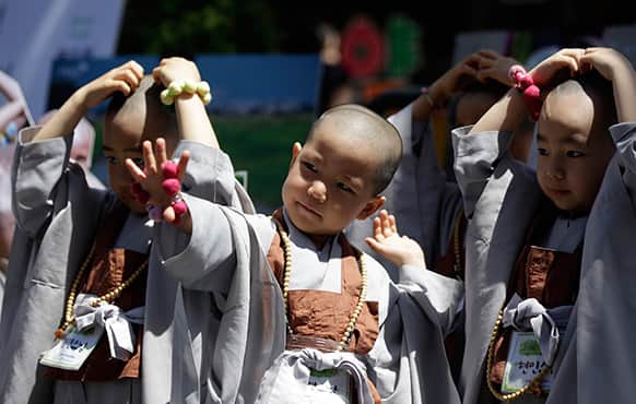 Shaven-headed young boys pose for photographers while attending a volunteer activity in Seoul, South Korea. They are among ten children who entered a temple to have an experience of monks` life for three weeks, called Little Buddha Camp, to celebrate upcoming Buddha`s birthday on May 17.