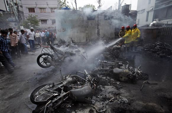 Firemen spray water on motorbikes that were gutted in a fire accident in Hyderabad. Around 25 vehicles were destroyed in a fire caused by a blast in an electrical transformer.