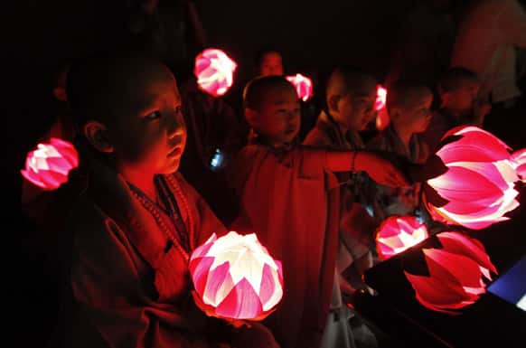 Shaven-headed young boys with lanterns watch a screen at SK Telecom T.um Museum in Seoul, South Korea. The children entered a temple to have an experience of monks` life for three weeks, called Little Buddha Camp, to celebrate upcoming Buddha`s birthday which falls on May 17.