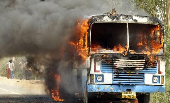 A bus is in flames after clashes between rival religious groups over possession of a hermitage, near Rohtak, about 60 kilometers from New Delhi.