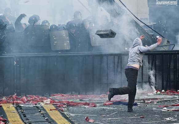 Supporter throw a concrete block toward riot police during Paris Saint-Germain soccer club celebrations for winning the the French league title at Trocadero Plaza in Paris. Paris Saint-Germain clinched its first French league title since 1994 by defeating Lyon 1-0 on Sunday.