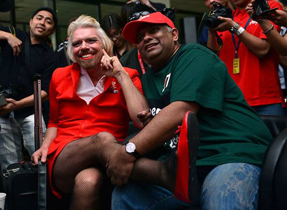 British entrepreneur Richard Branson, left, poses with AirAsia`s Chief Executive Tony Fernandes while dressed up as an AirAsia flight attendant at a low cost carrier terminal in Malaysia.