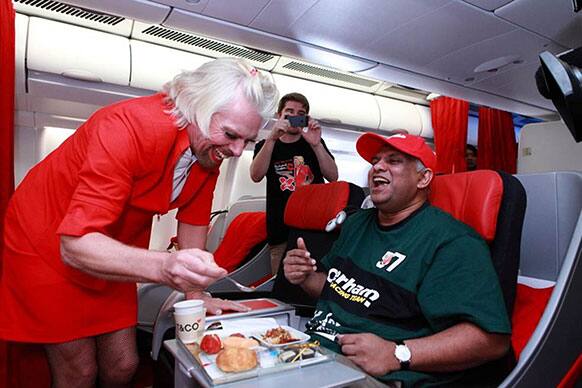 AirAsia chief Tony Fernandes, right, is served by British business magnate Richard Branson who is dressed as a female flight attendant, while flying from Perth, Australia to Kuala Lumpur, Malaysia.