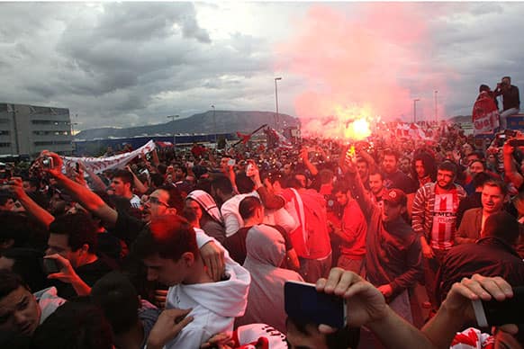 Olympiacos supporters light flares during the arrival of the team at Athens` Eleftherios Venizelos Airport at Spata, Greece.