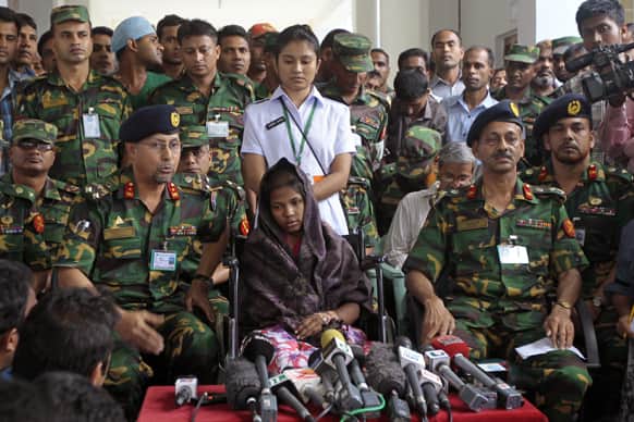Bangladeshi army doctors and other officers sit beside as Reshma Begum, center, the 19-year-old seamstress who spent 17 days trapped in the rubble of a collapsed factory building talks to the media at a hospital in Savar, near Dhaka, Bangladesh.