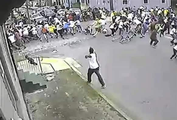This image taken from video and provided by the New Orleans Police Department, a possible shooting suspect in a white shirt, shoots into a crowd of people, in New Orleans.