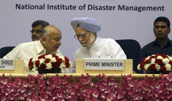 Prime Minister Manmohan Singh, center, speaks to Indian union minister for Home Sushilkumar Shinde during the first session of National Platform for Disaster Risk Reduction, in New Delhi.