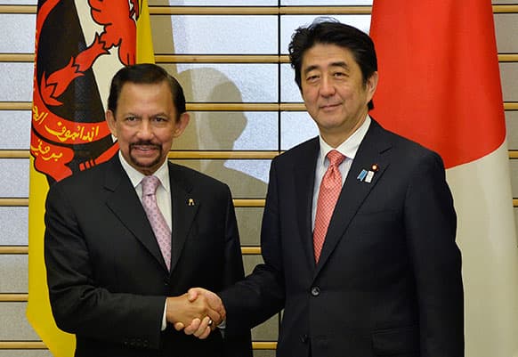 Sultan of Brunei Hassanal Bolkiah, left, shakes hands with Japanese Prime Minister Shinzo Abe at the start of their meeting at the latter`s official residence in Tokyo.
