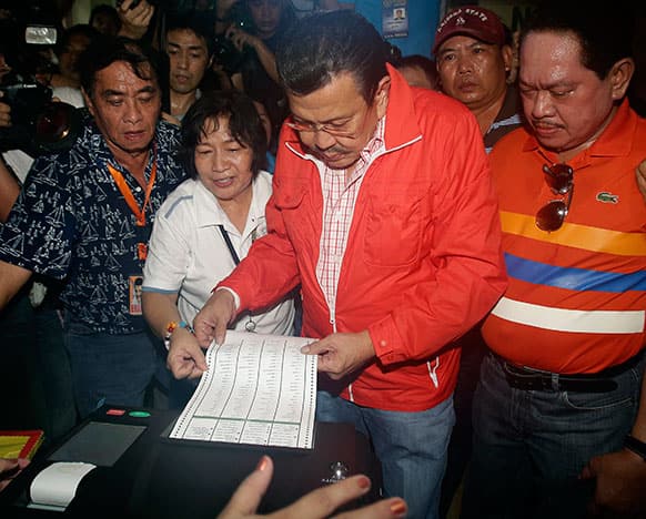Former Philippine President Joseph Estrada, who is now a candidate for mayor of Manila enters his vote at a school used as a voting center during mid-term elections in Manila, Philippines.