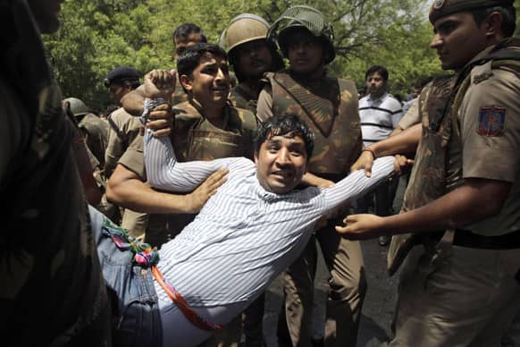 Policemen detain an activist of the youth wing of opposition Janata Party protesting near Indian Prime Minister Manmohan Singh`s residence demanding his resignation in New Delhi.