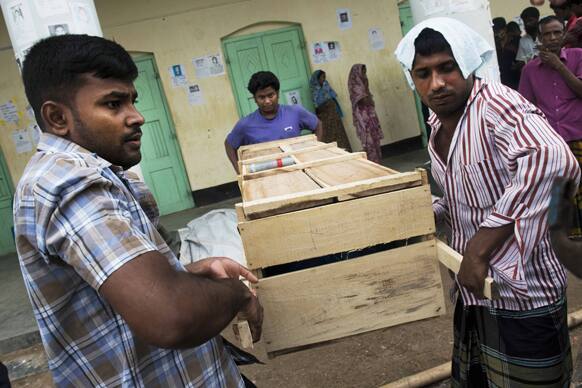 Bangladeshi relatives prepare to load onto a truck a coffin containing the body of a victim killed in the April 24 garment factory building collapse in Savar, near Dhaka, Bangladesh.
