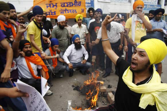 Sikhs shout slogans after they burnt an effigy of Indian government and others as they demand punishment for those involved in the country`s 1984 anti-Sikh riots during a protest in Jammu.
