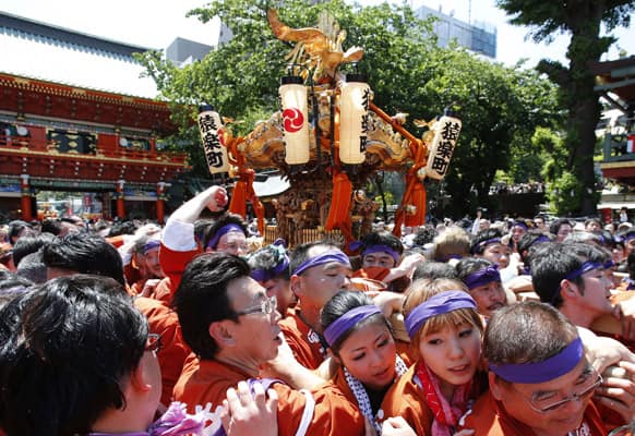 Participants parade with a portable shrine through the precincts of Kanda Myojin shrine during the biennial Kanda Myojin Festival. The festival was held first time in four years following the March 11, 2011 earthquake and tsunami in Japan.