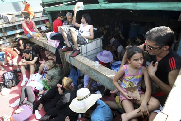 Iranian asylum seekers who were caught in Indonesian waters while sailing to Australia, sit on a boat, at Benoa port in Bali, Indonesia.
