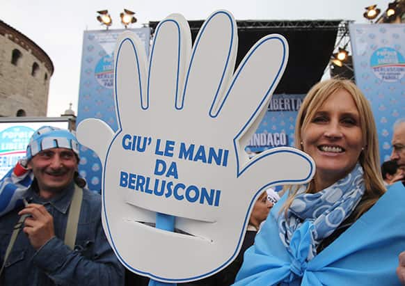 Silvio Berlusconi`s supporters hold a cutout hand reading