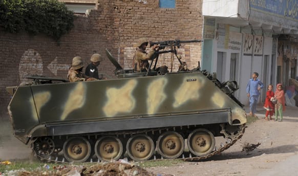 Pakistani army soldiers in an APC patrol a day before the nationwide election, in Peshawar, Pakistan.