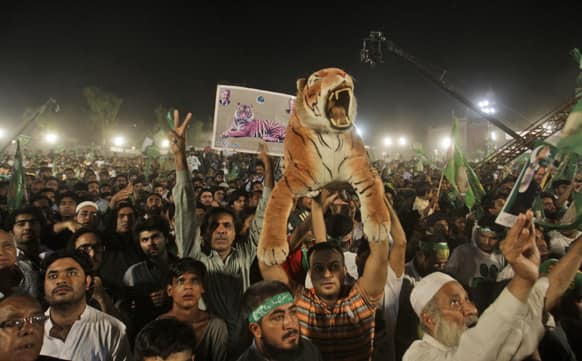 Supporters of Pakistan`s former Prime Minister Nawaz Sharif, listen to him delivering a speech, during an election campaign rally, in Lahore, Pakistan.