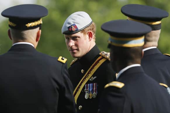 England`s Prince Harry is accompanied by military officials as he visits Section 60 at Arlington National Cemetery. The British soldier-prince is spending most of his week in the US honoring the wounded and the dead of war.