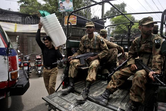 Pakistani army soldier, guard outside the city court, as a policeman carries ballot boxes to polling stations, in Lahore. Pakistan is scheduled to hold parliamentary elections on May 11.