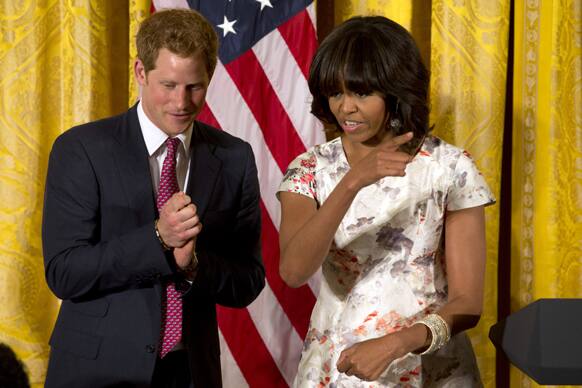 First lady Michelle Obama gestures during a surprise visit from Prince Harry at an event in honor of military mothers in the East Room of the White House in Washington.
