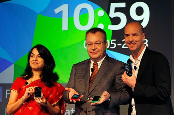 Nokia`s Chief Executive Officer Stephen Elop, center, head developer Sangeeta Bavi, left, and design head Peter Skillman display Nokia Asha 501 smartphones during its launch in New Delhi. Nokia unveiled the first of a new family of Asha smartphones with the Nokia Asha 501 priced at US$99.