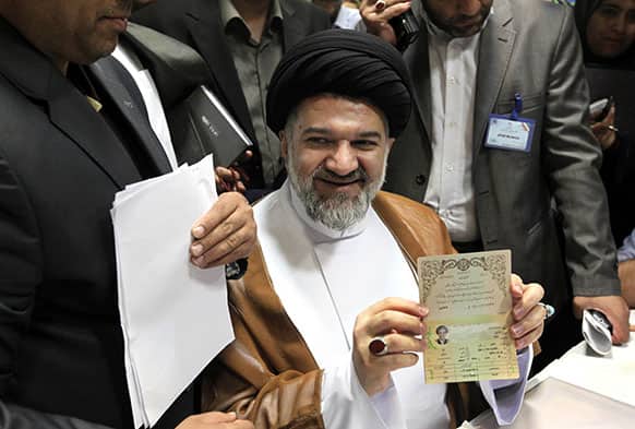 Radical Iranian cleric Mohammad Bagher Kharrazi, shows his identification to the media, as he registers for his candidacy for the upcoming presidential election, at the election headquarters of the interior ministry in Tehran, Iran.