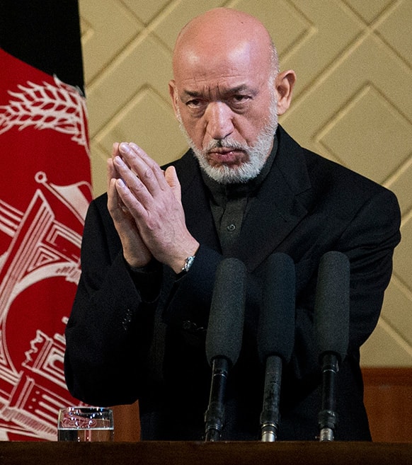 Afghan President Hamid Karzai gestures during a ceremony at Kabul University in Kabul, Afghanistan. Karzai said he is ready to let the US have nine bases in the country after the 2014 combat troop pullout, but wants Washington’s “security and economic guarantees” first.