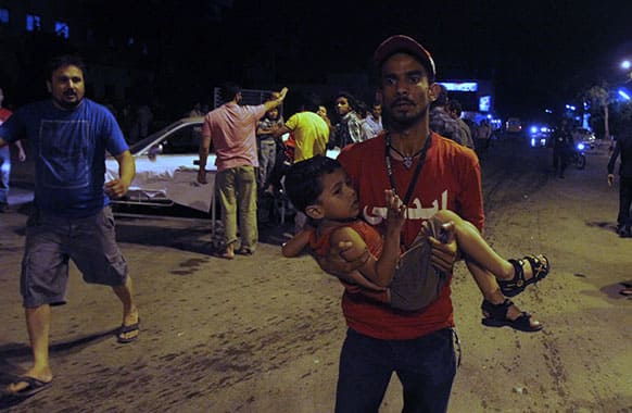 A Pakistani volunteer carries an injured boy to hospital following an explosion in Karachi, Pakistan.
