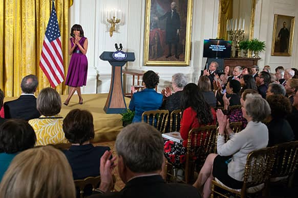 First lady Michelle Obama applauds after awarding the 2013 National Medals for Museum and Library Service to recipients in the East Room of the White House.