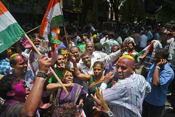 Congress party supporters celebrate outside a counting station after hearing news of the party leading in the recently held state elections in Bangalore.