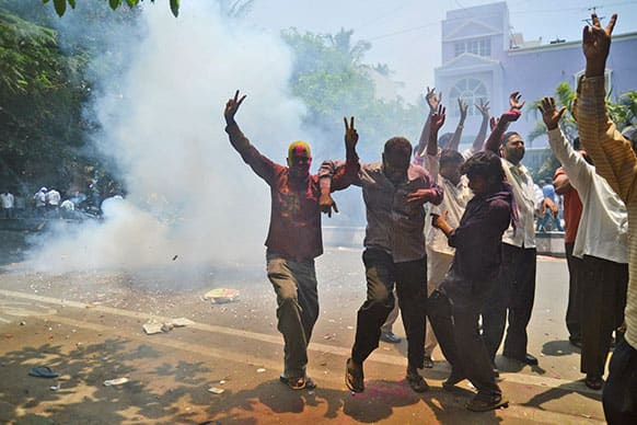 Congress party supporters celebrate outside a counting station after hearing news of the party leading in the recently held state elections in Bangalore.
